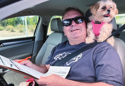 A member and his dog laugh and smile for the camera