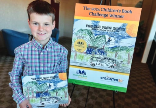 The winner of the Enlighten contest poses with his winning book