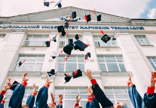 Graduates are shown tossing their caps