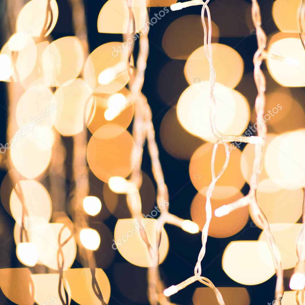 The image displays a close-up of holiday string lights with a blurred background of warm, glowing bokeh circles, creating a festive ambiance.