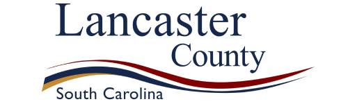 Logo of Lancaster County, South Carolina, featuring stylized text and a wavy tricolor line in blue, gold, and red beneath the text.