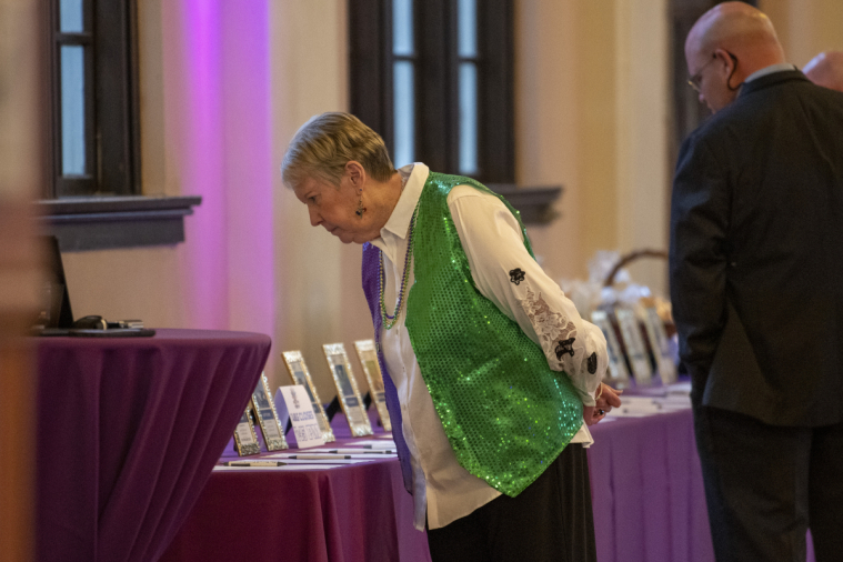 A woman seriously ponders some auction items.