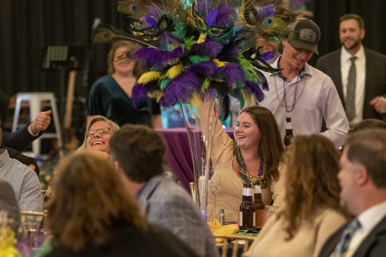 A smiling prizewinner holds up her hand to signal her win.