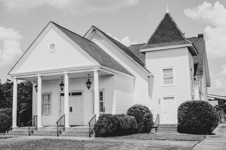 A white wooden church is pictured in black and white.