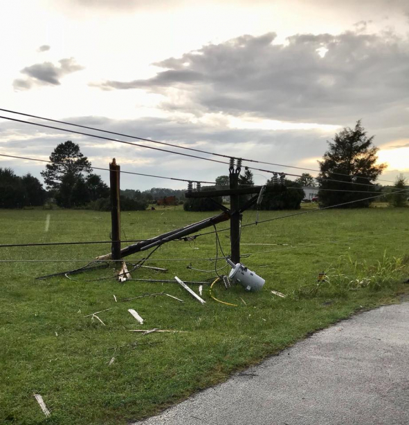 Broken electric poles, wires, and transformer on the ground.