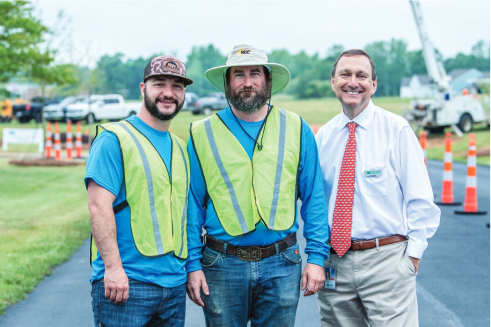 Our CEO poses for a picture with 2 linemen